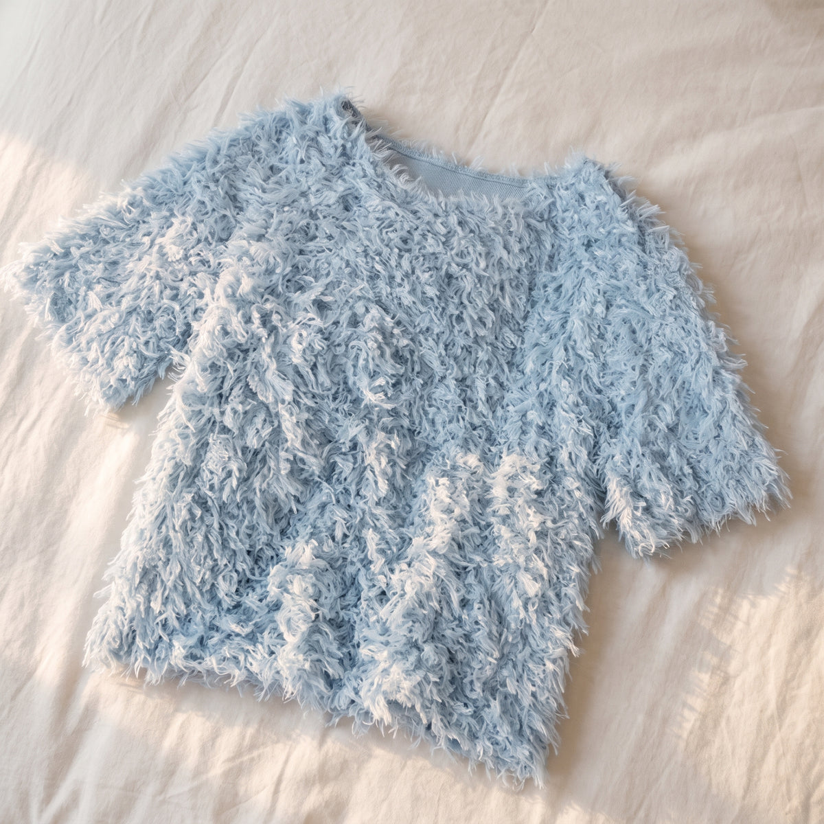 Pull en maille effet plumes, coloris Bleu ciel, posé à plat