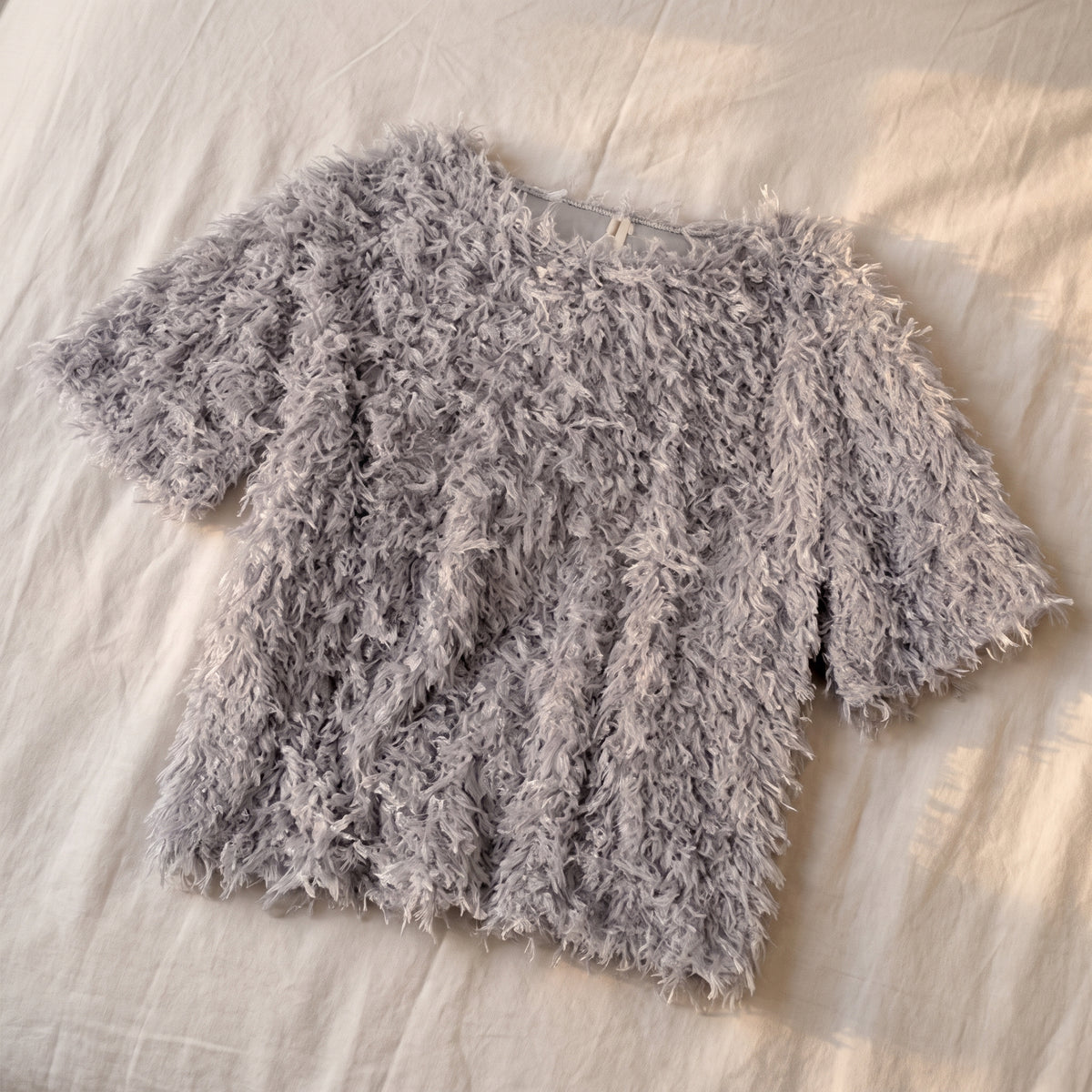 Pull en maille effet plumes, coloris Gris perle, posé à plat