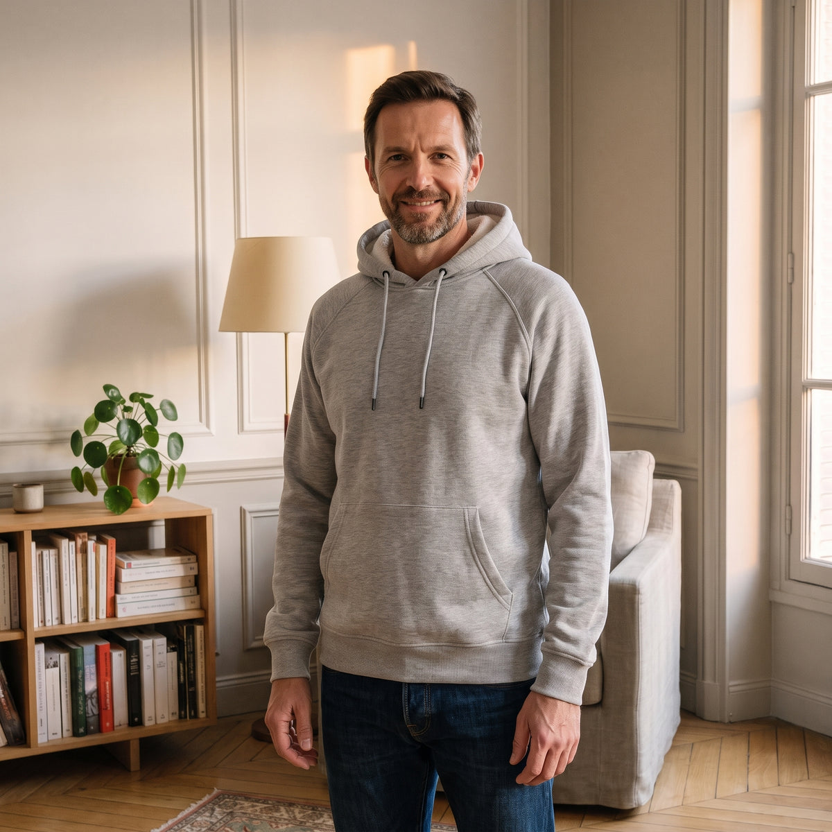 Sweat à capuche gris clair porté dans un salon
