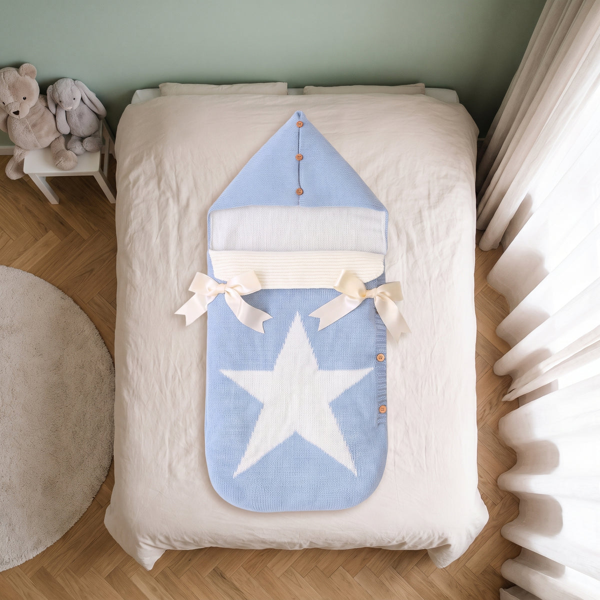Gigoteuse bébé bleu ciel à capuche, posée sur le lit d'une chambre d'enfant