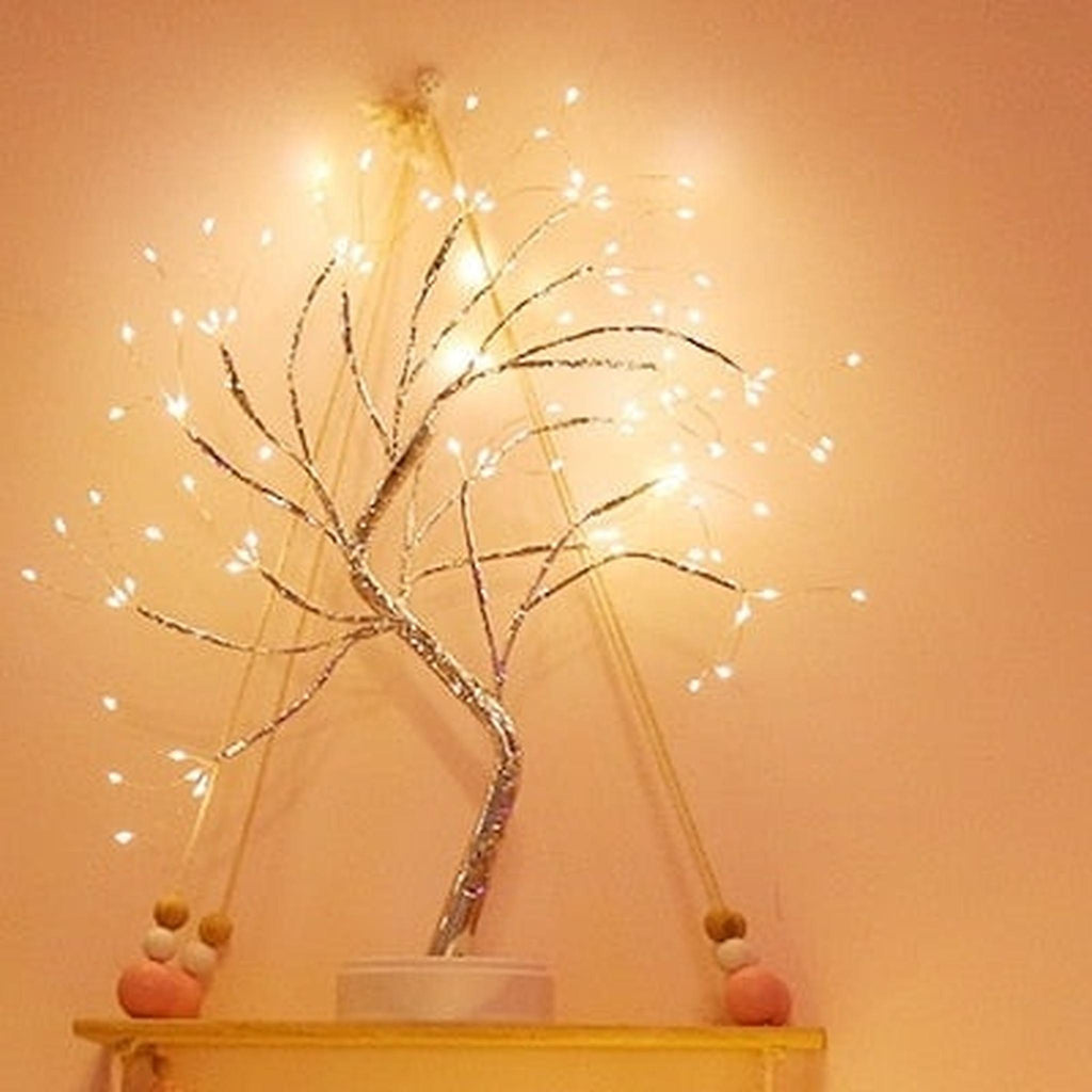 Arbre lumineux en fil de cuivre sur une étagère murale