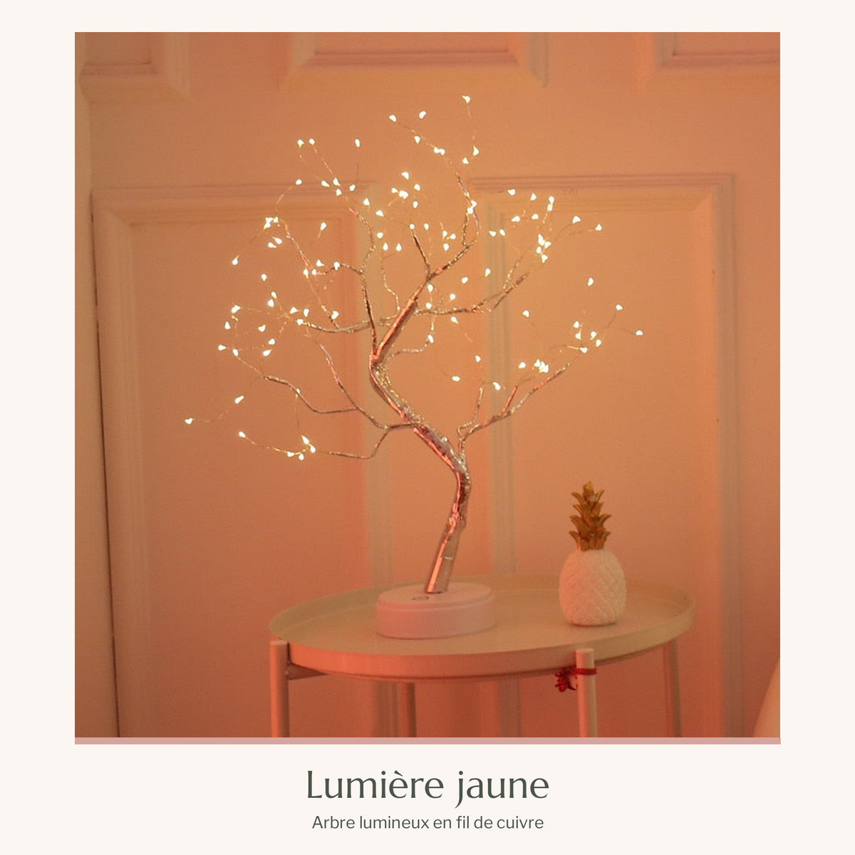 Arbre lumineux en fil de cuivre à lumière jaune sur une petite table près du mur