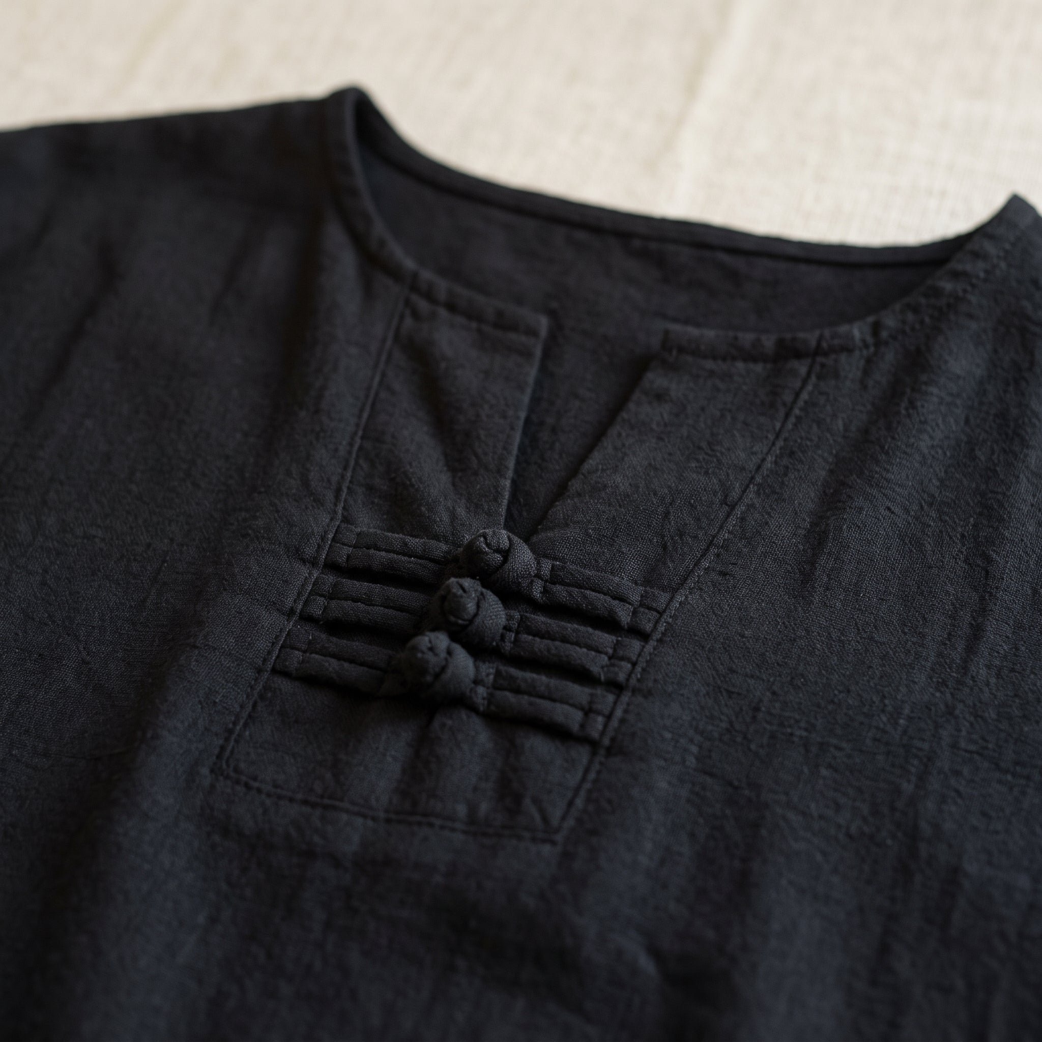 Encolure en V et ses trois nœuds de tissu sur l'ensemble noir, en gros plan Image