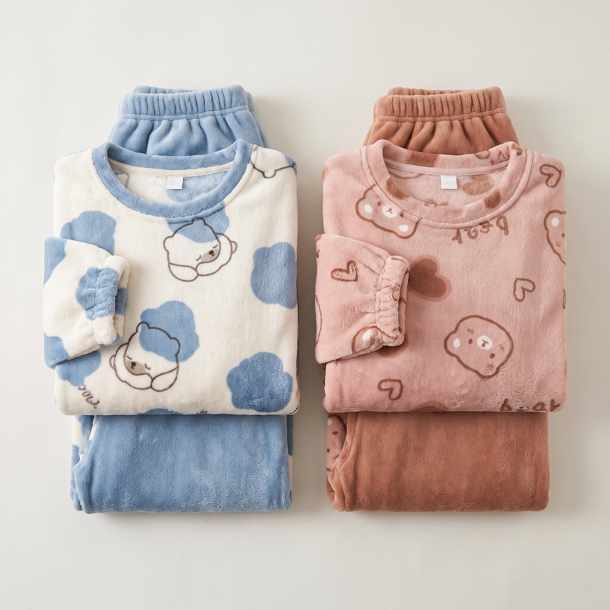 Deux pyjamas en pilou-pilou pliés côte à côte, motif ours bleu et ours rose Image