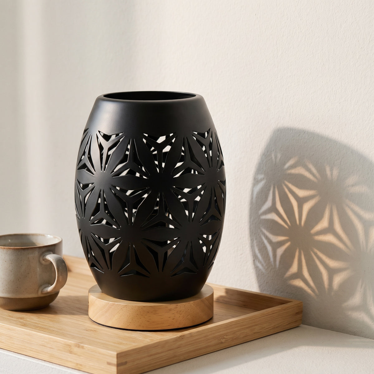 Lampe photophore de trois quarts, le motif projeté sur le mur clair