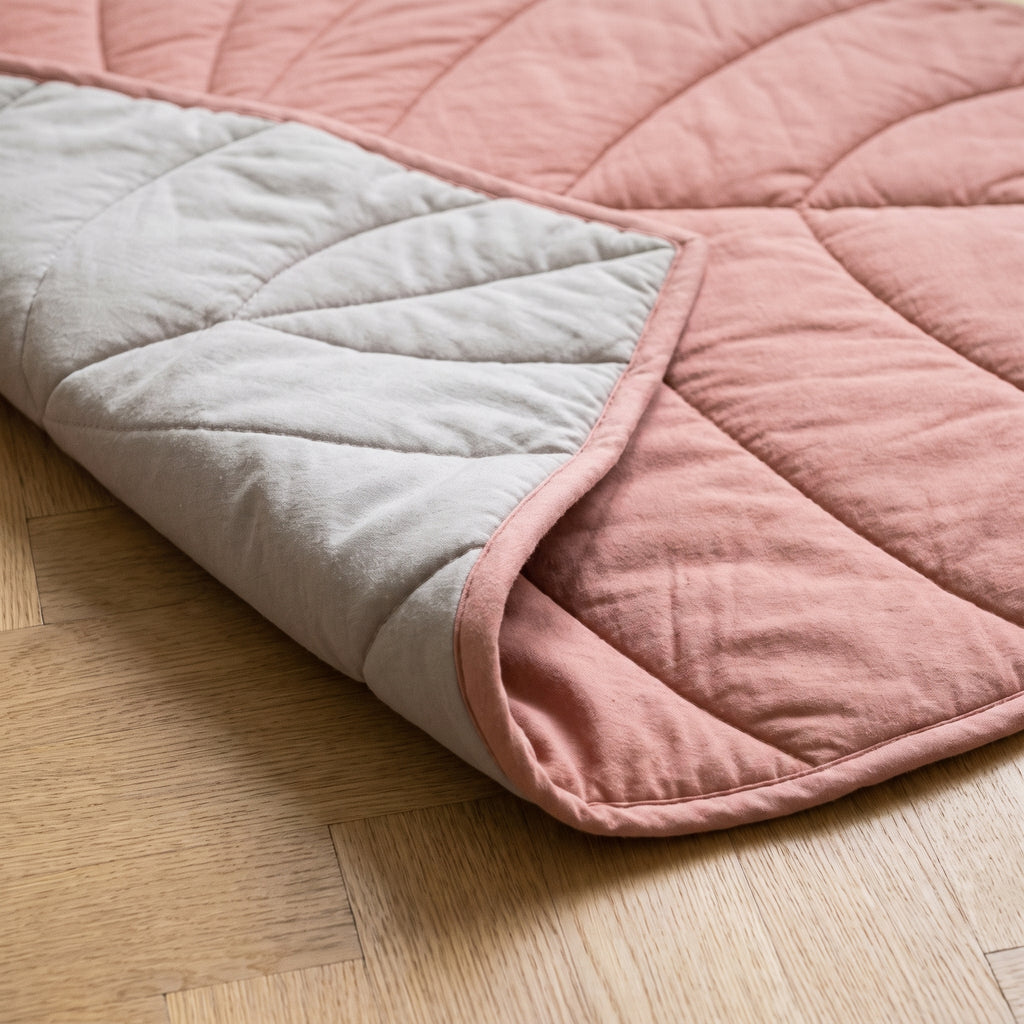 Envers greige clair du tapis feuille rose, coin rabattu et biais rose sur le tour