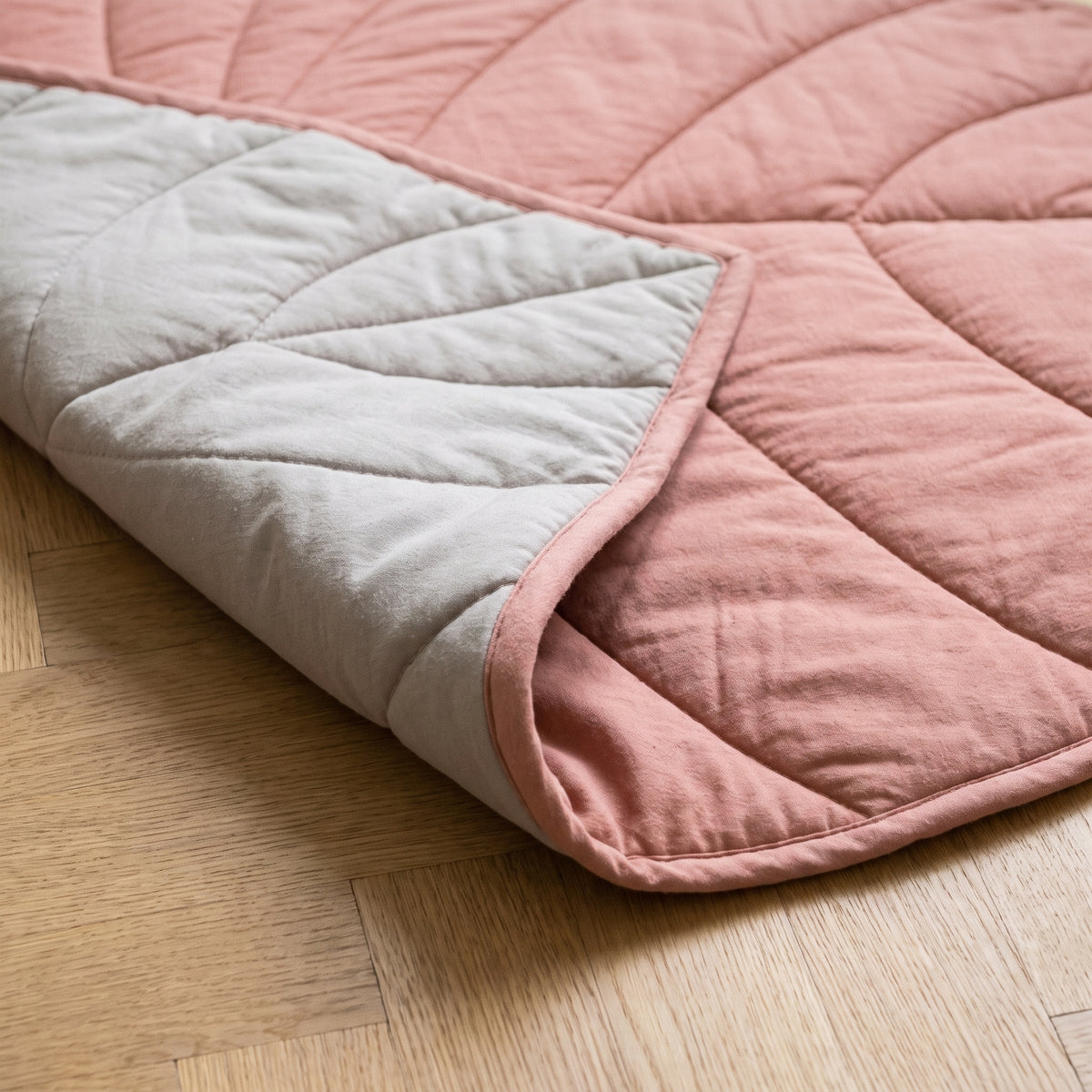 Envers greige clair du tapis feuille rose, coin rabattu et biais rose sur le tour