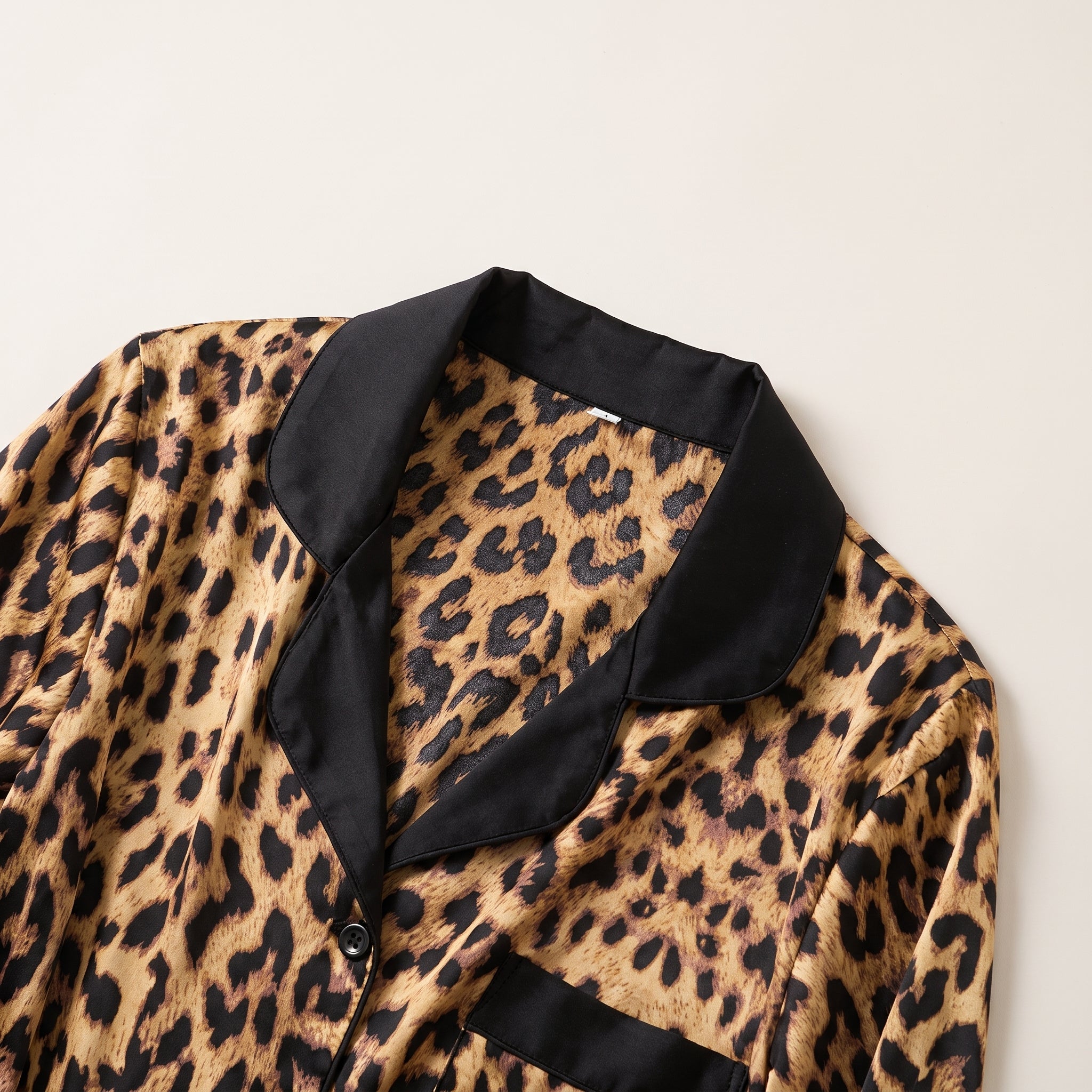 Col tailleur et parement noir d'une veste de pyjama en satin léopard Image