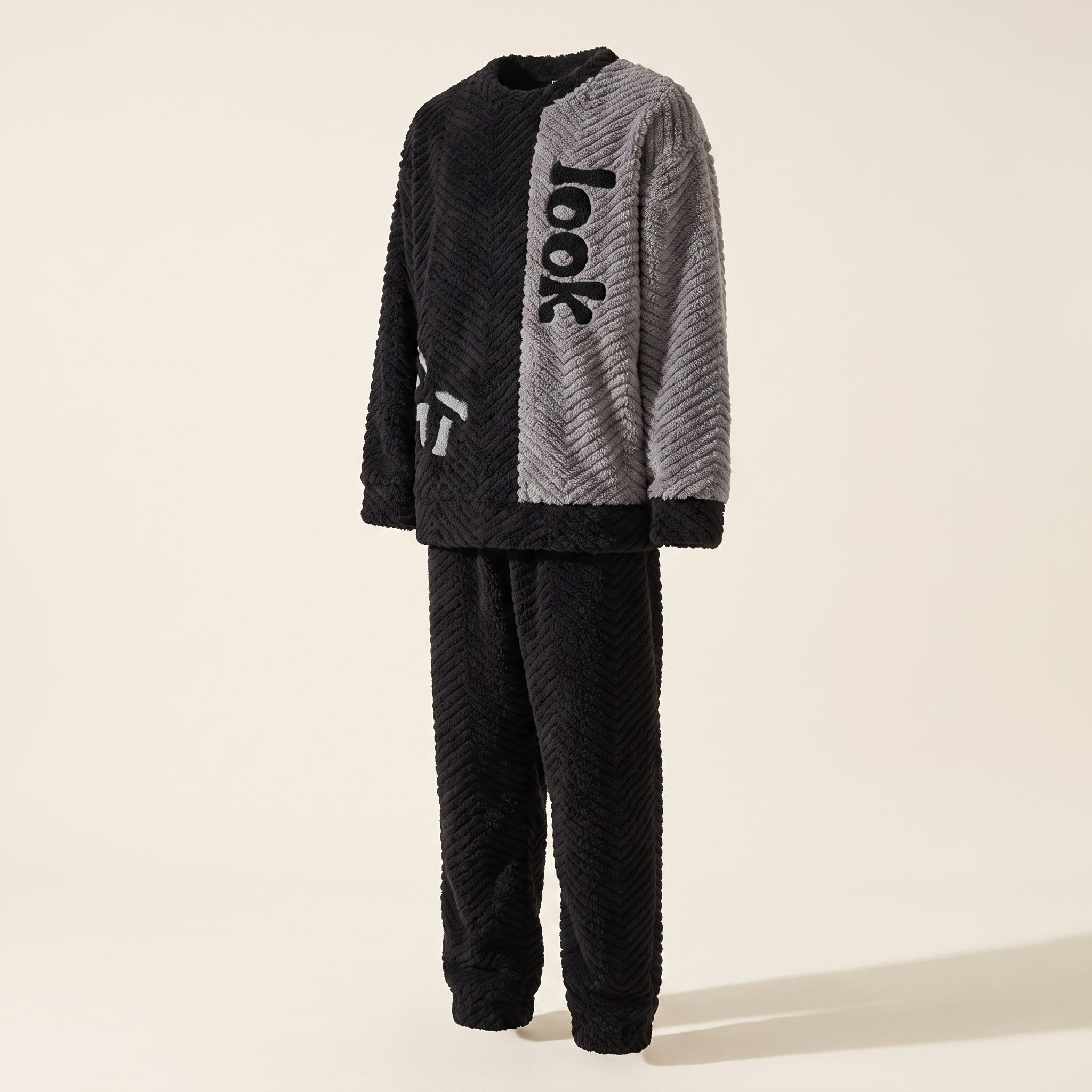 Pyjama deux pieces noir et gris vu de trois quarts sur mannequin invisible : ampleur du haut et longueur du pantalon. Image