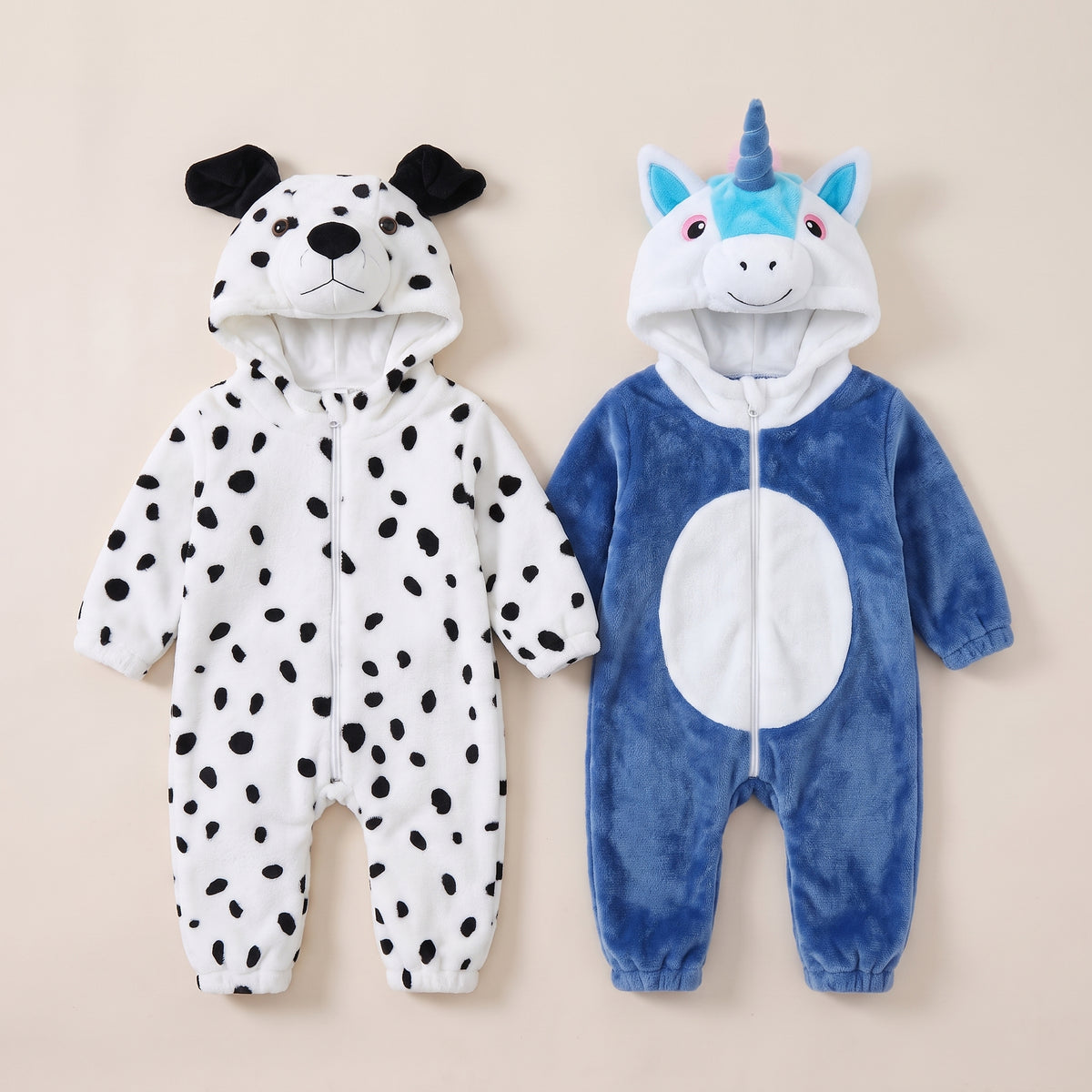 Deux barboteuses déguisement posées à plat, dalmatien et licorne Image