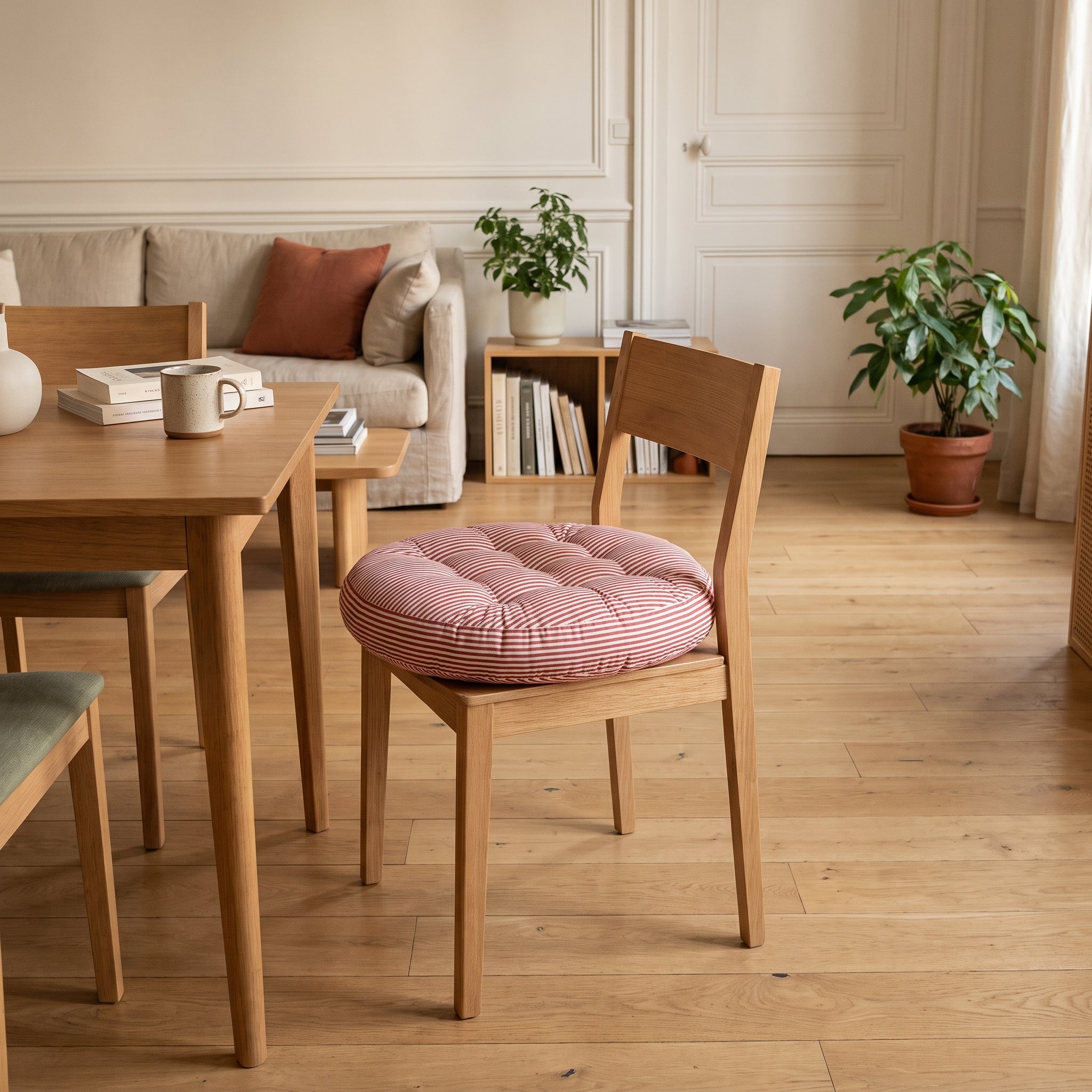 Coussin de sol rayé rouge et blanc posé sur l'assise d'une chaise en bois du coin repas Image