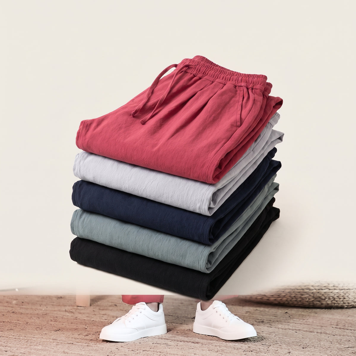 Trois pantalons sarouel pliés en pile, gris clair, rouge et noir Image