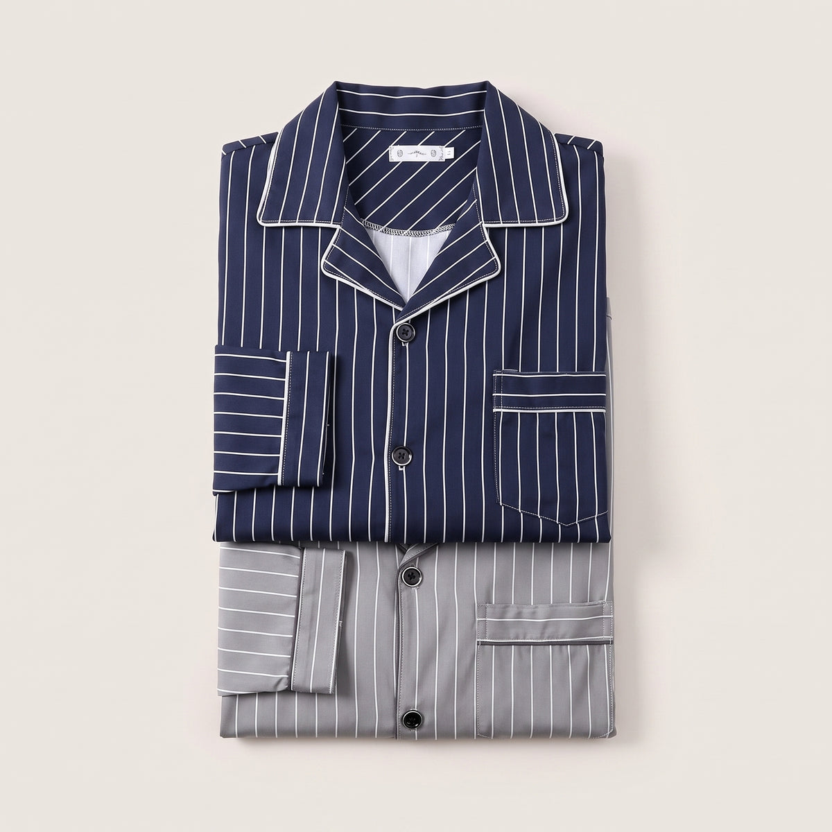 Les deux pyjamas à rayures pliés côte à côte, bleu marine et gris Image