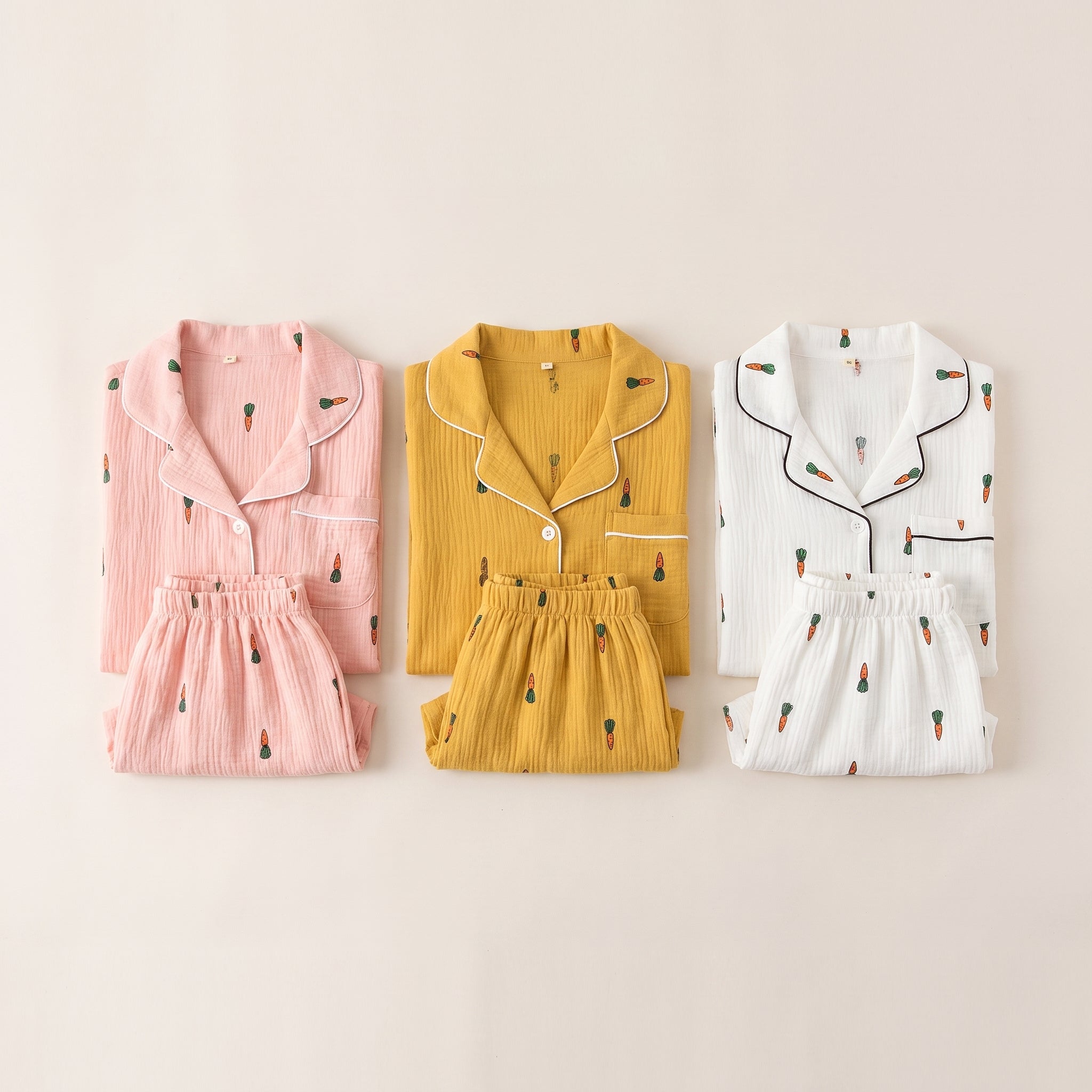 Trois pyjamas courts en gaze de coton posés côte à côte, rose poudré, moutarde et blanc Image