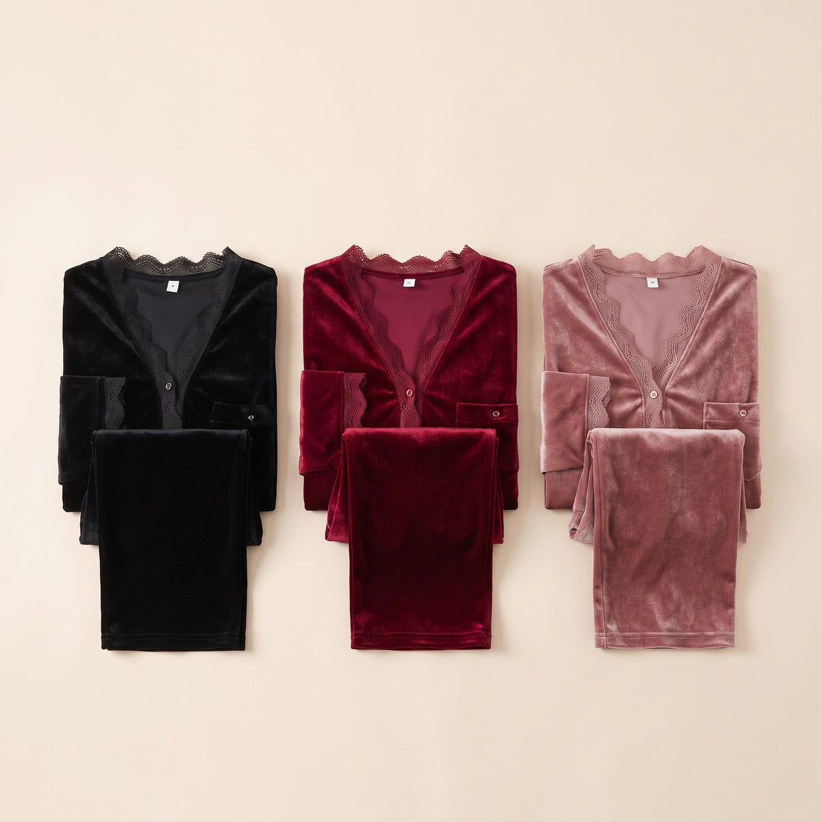Trois pyjamas en velours posés côte à côte, noir, rouge bordeaux et vieux rose Image
