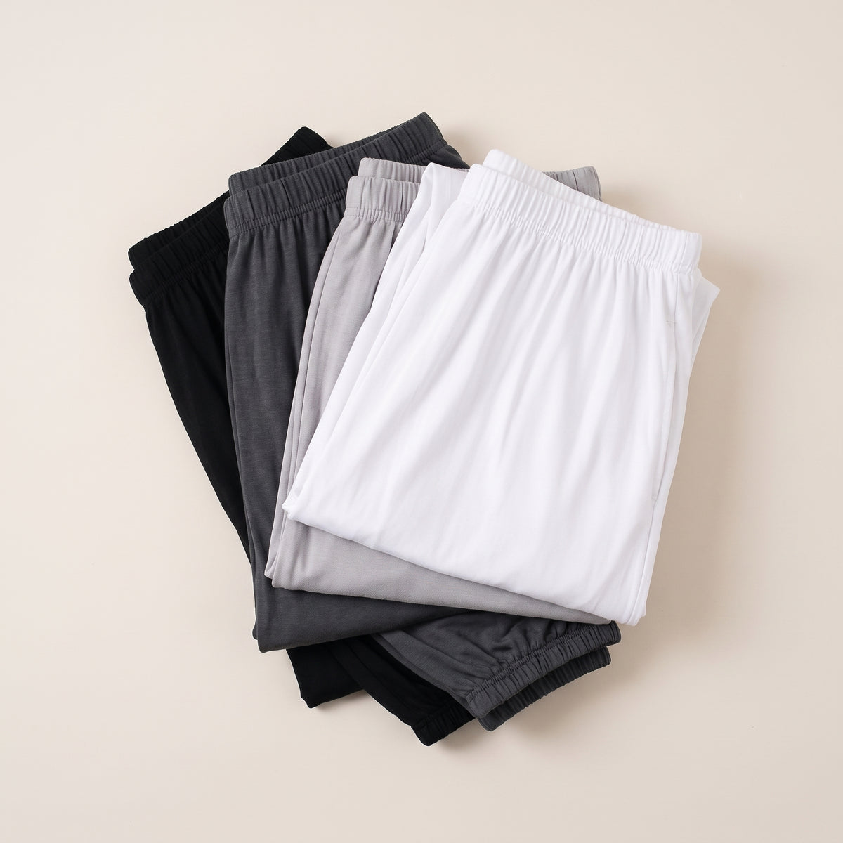 Quatre pantalons sarouel de yoga pliés en pile, du noir au blanc Image
