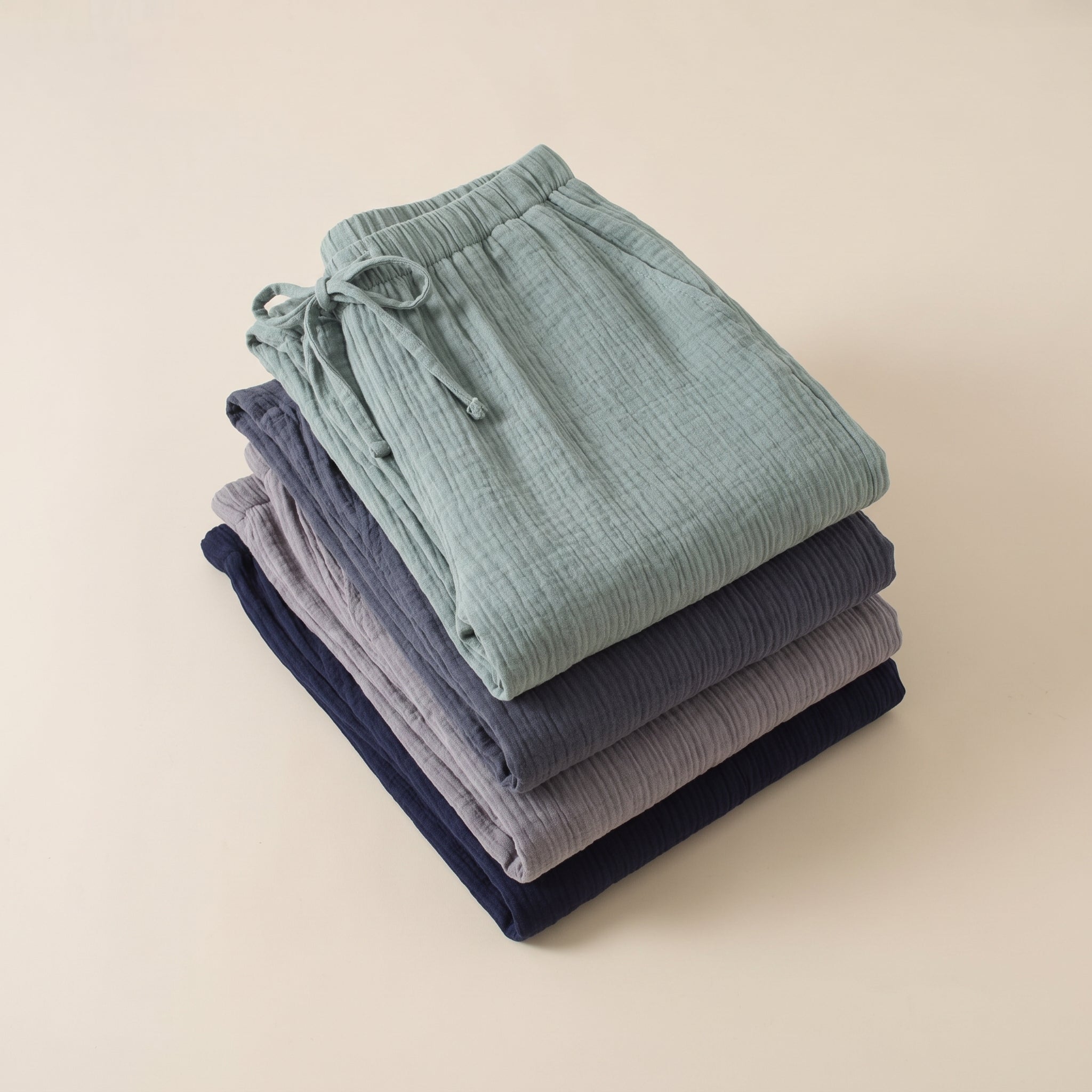 Quatre pantalons de pyjama en gaze de coton pliés en pile, les quatre teintes Image