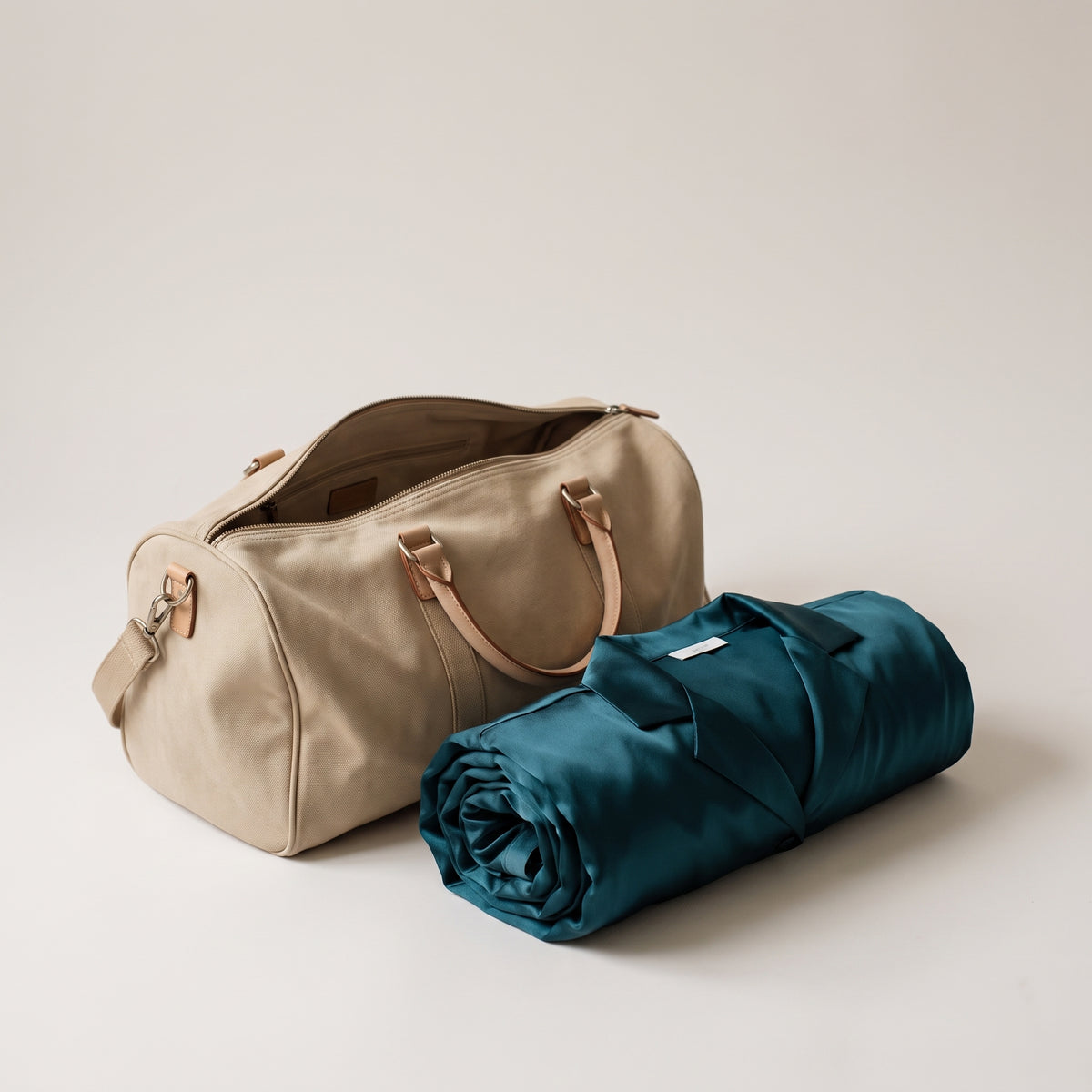 Pyjama en satin roulé à côté d un sac de voyage en toile Image