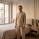 Pyjama homme beige ample porté dans une chambre lumineuse