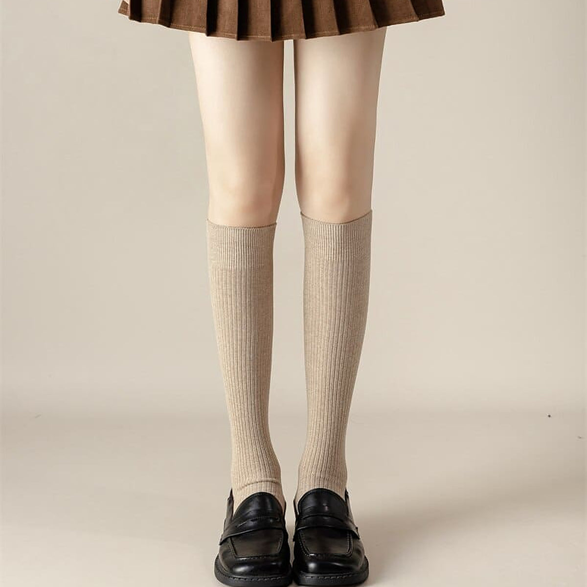 Chaussettes hautes beige portees sous le genou avec des mocassins