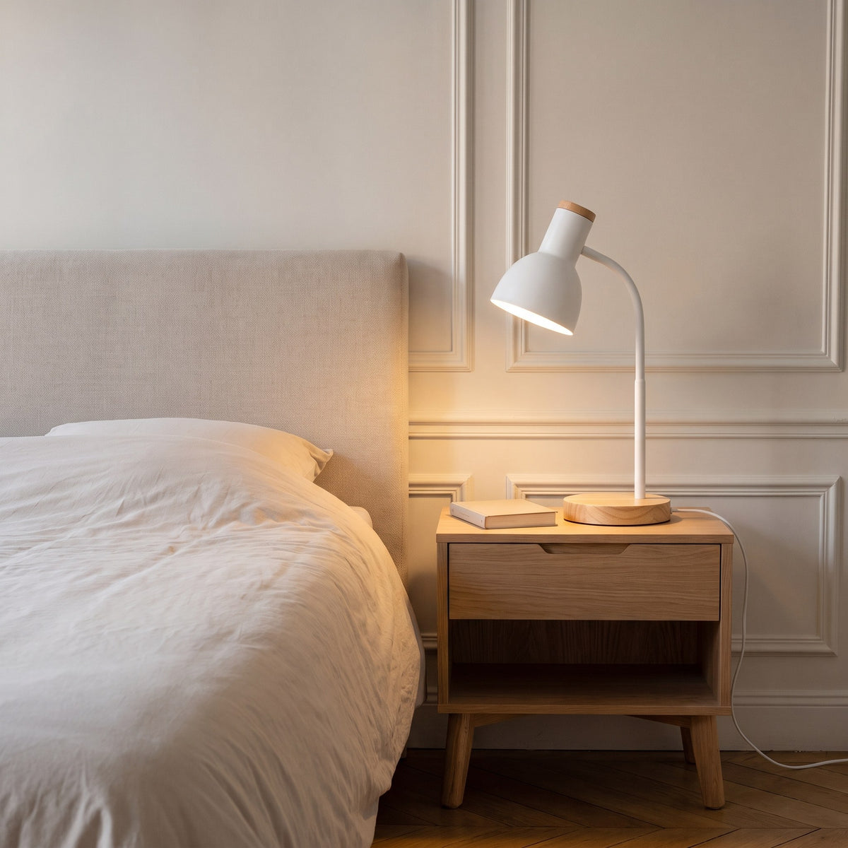 Lampe de bureau blanche allumée sur une table de chevet