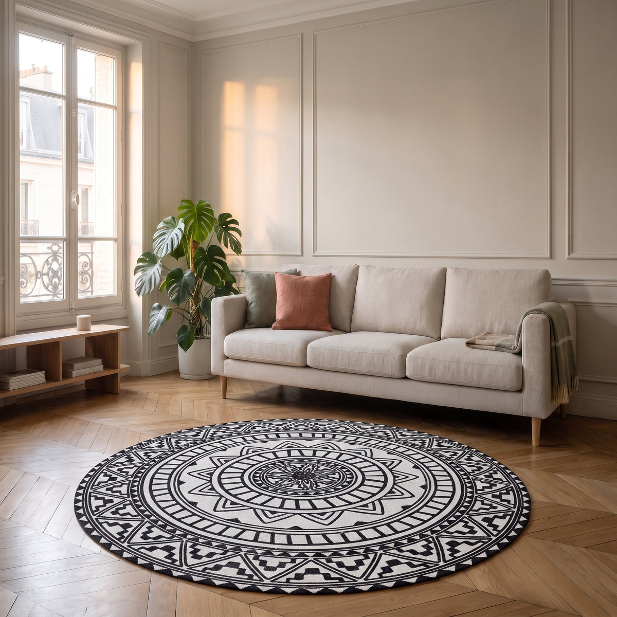Tapis rond mandala blanc et noir posé devant un canapé dans un salon