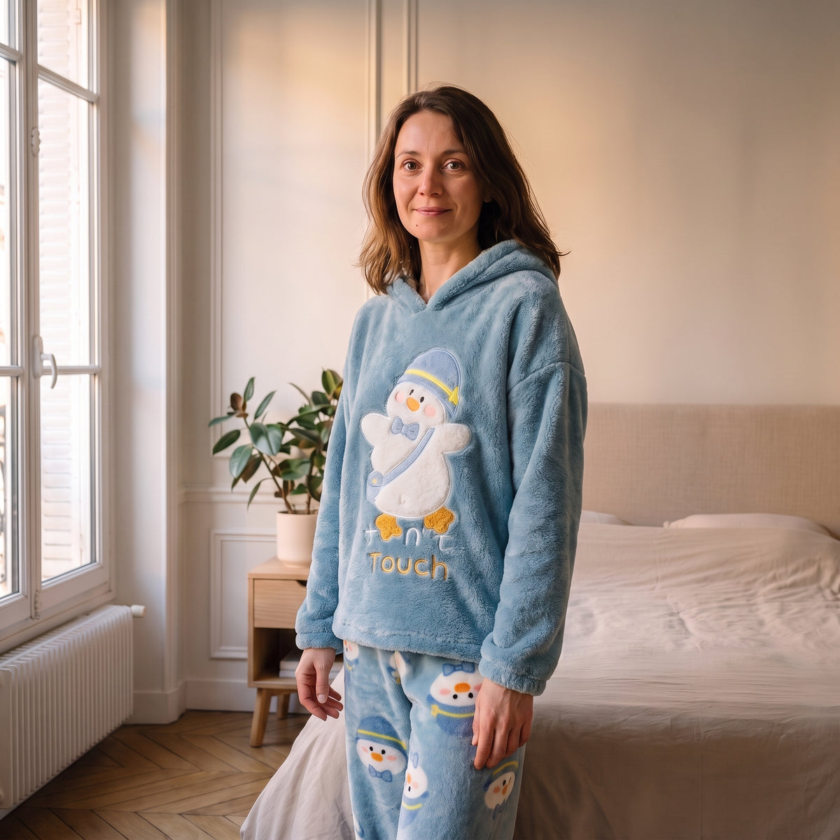 Femme portant le pyjama d'hiver bleu ciel imprimé dans une chambre lumineuse Image