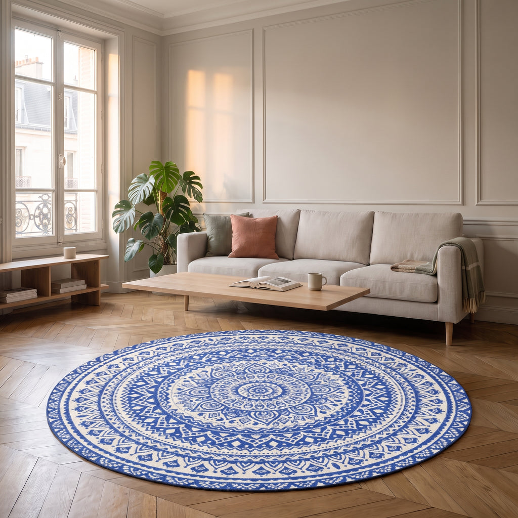 Tapis rond mandala bleu clair et blanc posé devant un canapé dans un salon
