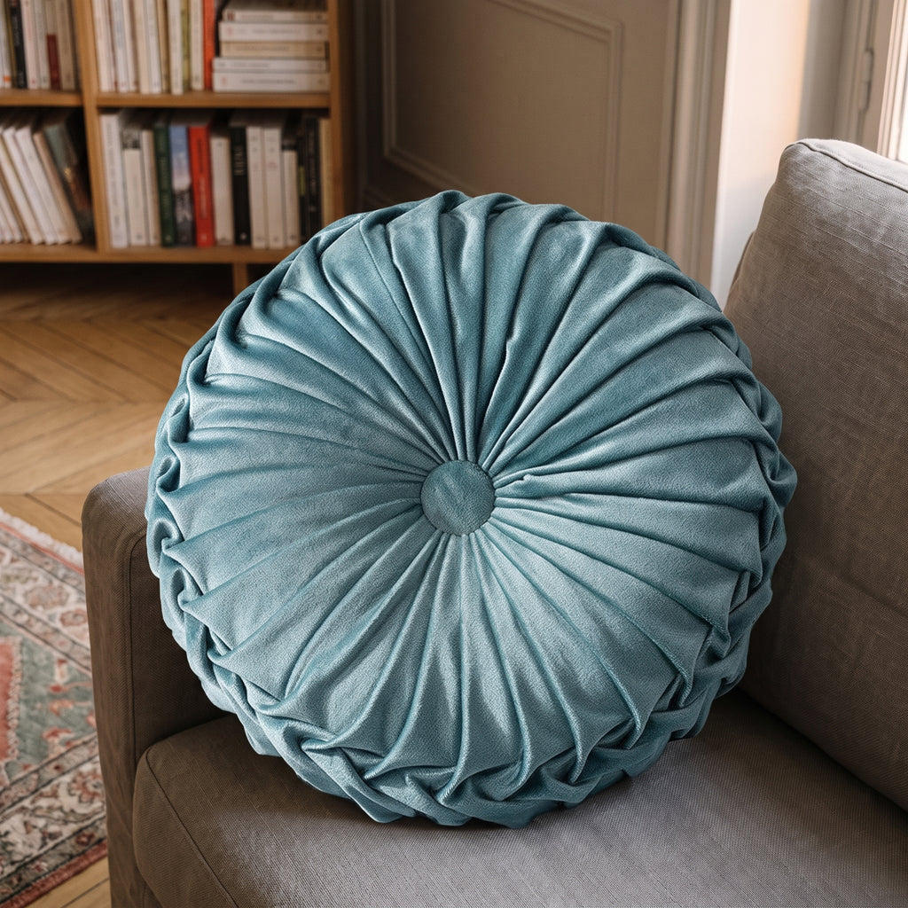 Coussin rond plissé en velours bleu clair, détail du velours, du plissé et du bouton central