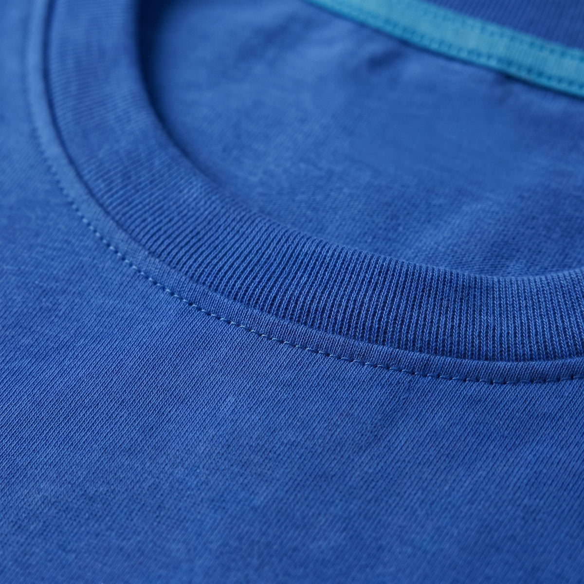 Gros plan sur le col rond côtelé du t-shirt bleu foncé