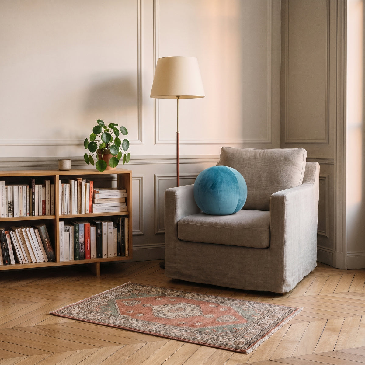 Coussin rond nordique en velours bleu foncé, posé dans un fauteuil de lecture