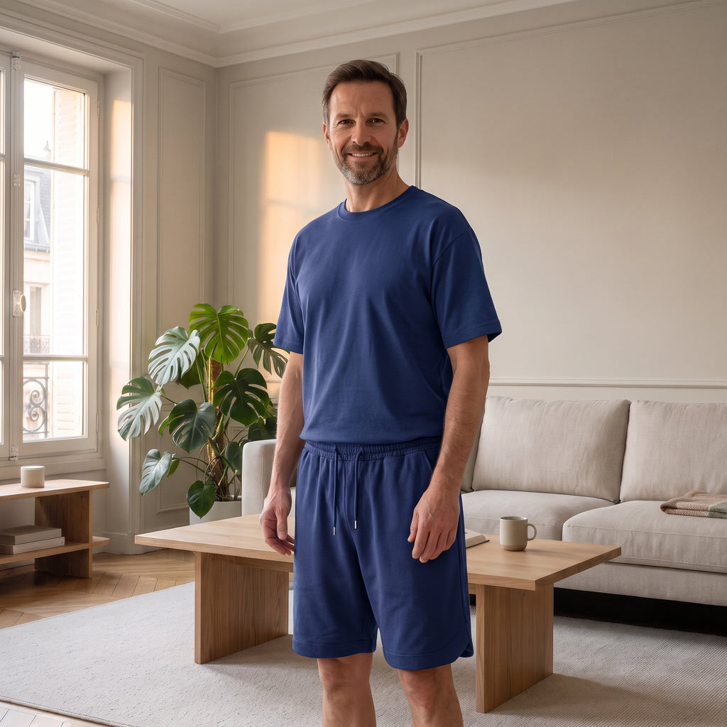 Homme du casting portant l’ensemble bleu à t-shirt et short dans le salon