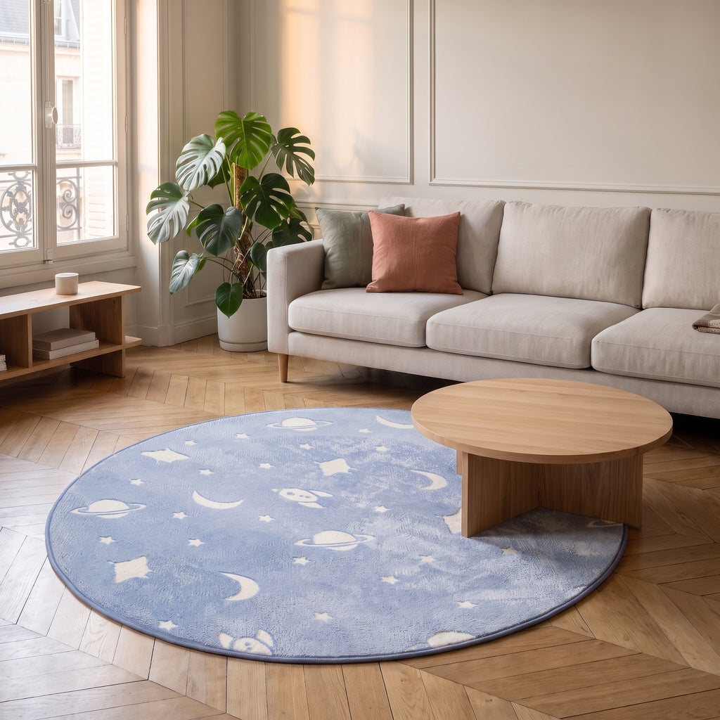Tapis rond phosphorescent bleu à planètes et fusées devant un canapé