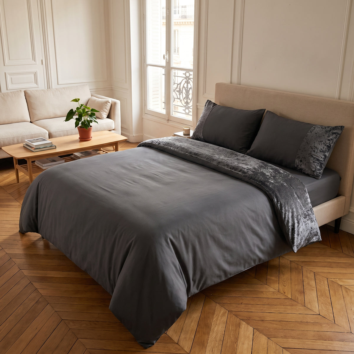 Parure de lit bi-matière gris foncé sur un lit fait, la bande de velours frappé repliée en haut de la housse
