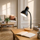 Lampe de bureau noire allumée sur la table basse du salon