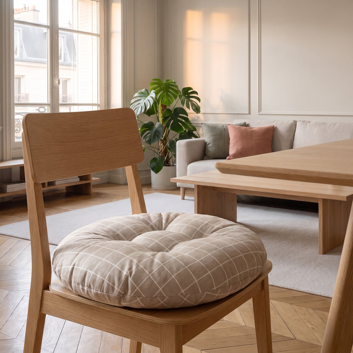 Coussin de sol rond posé en galette sur l'assise d'une chaise en bois clair Image