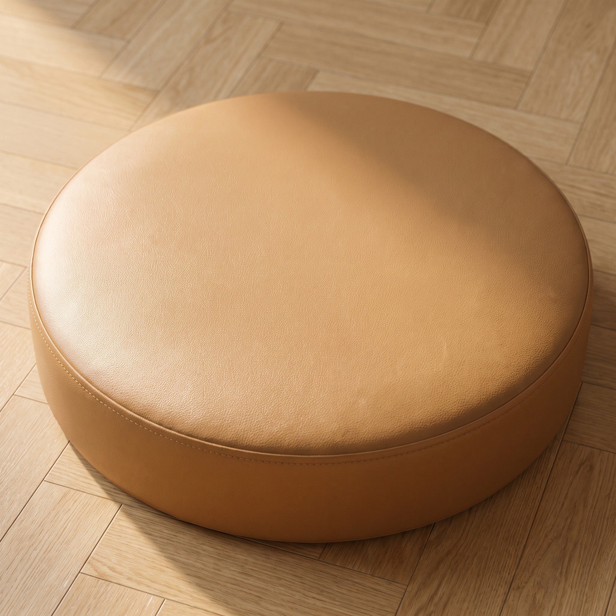 Coussin de sol rond camel vu de dessus sur un parquet clair, lumière rasante sur la face plate et piqûre sur le tour Image