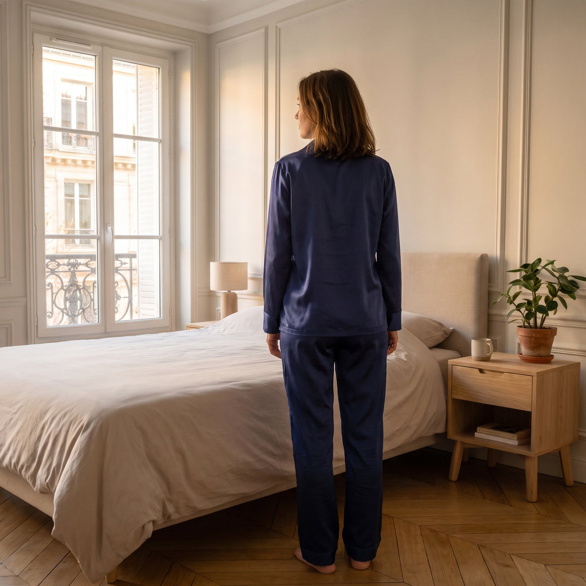 Vue de dos du pyjama satiné bleu dans une chambre lumineuse