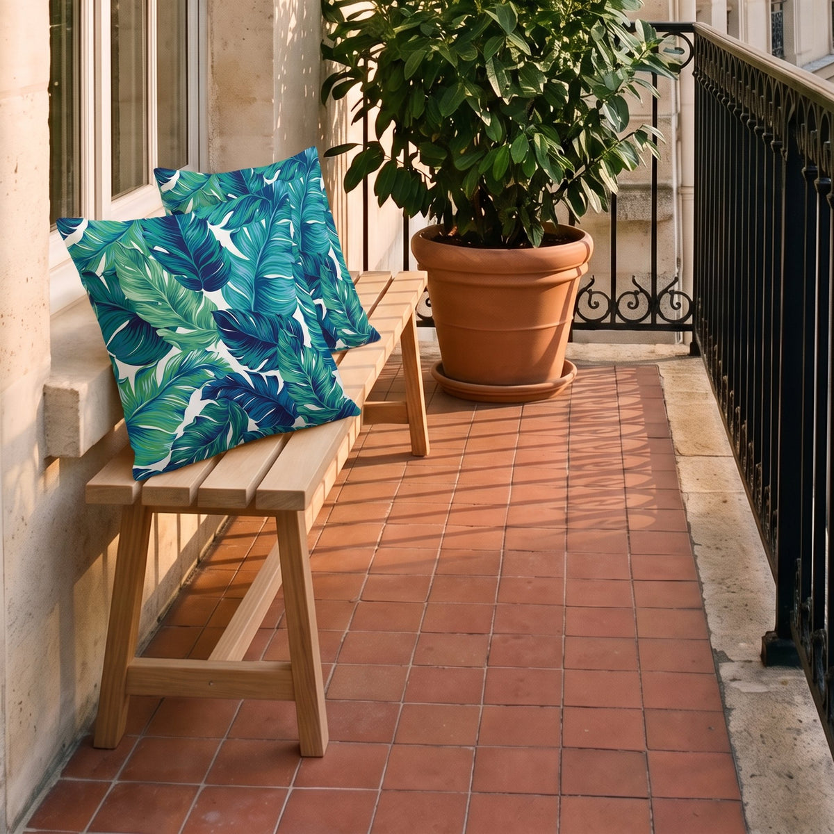 Deux housses de coussin à feuillage posées sur le banc d'un balcon