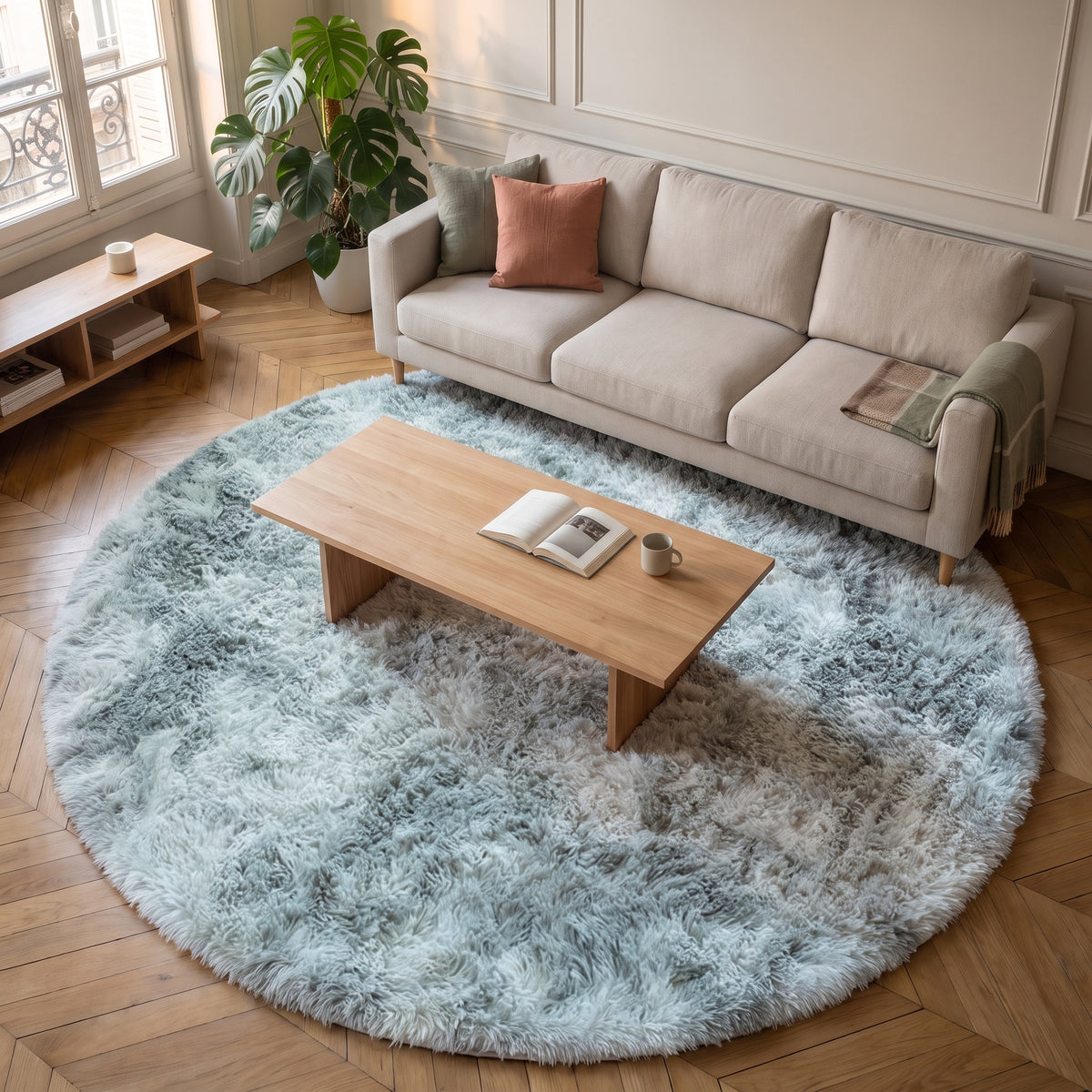 Tapis rond à poils longs vu de haut, la table basse au centre et le canapé sur son bord