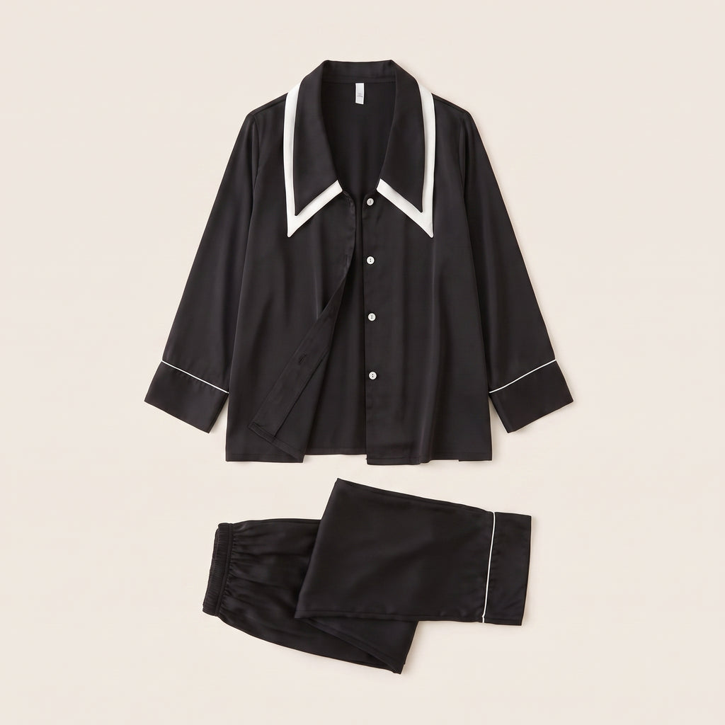 Pyjama en satin noir à liseré blanc, chemise et pantalon posés à plat