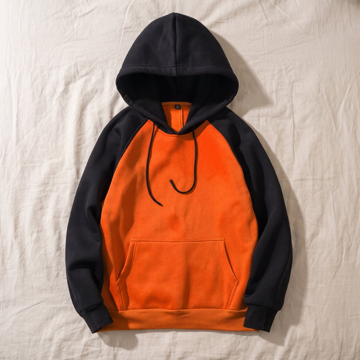 Sweat homme bicolore, Capuche orange et noir, posé à plat
