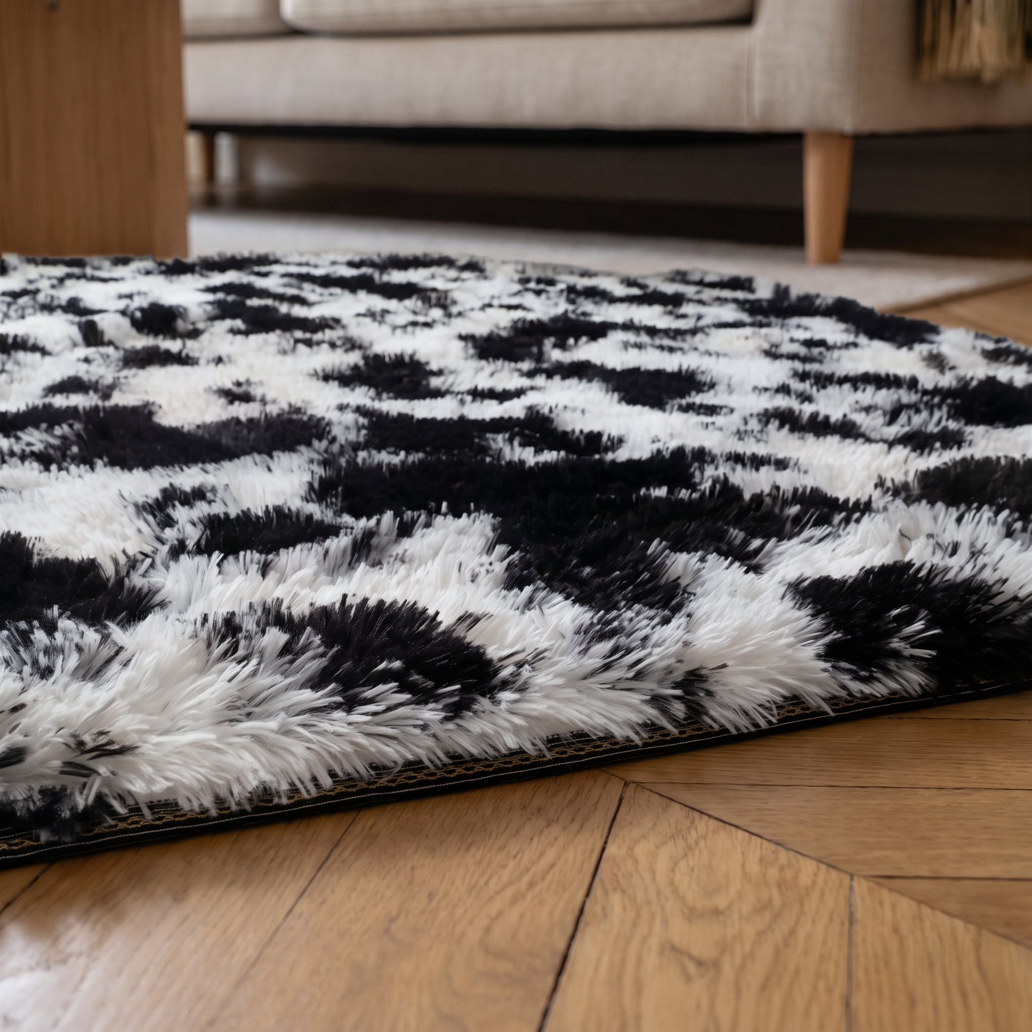 Bord du tapis vache sur le parquet, lisière noire et galon doré Image