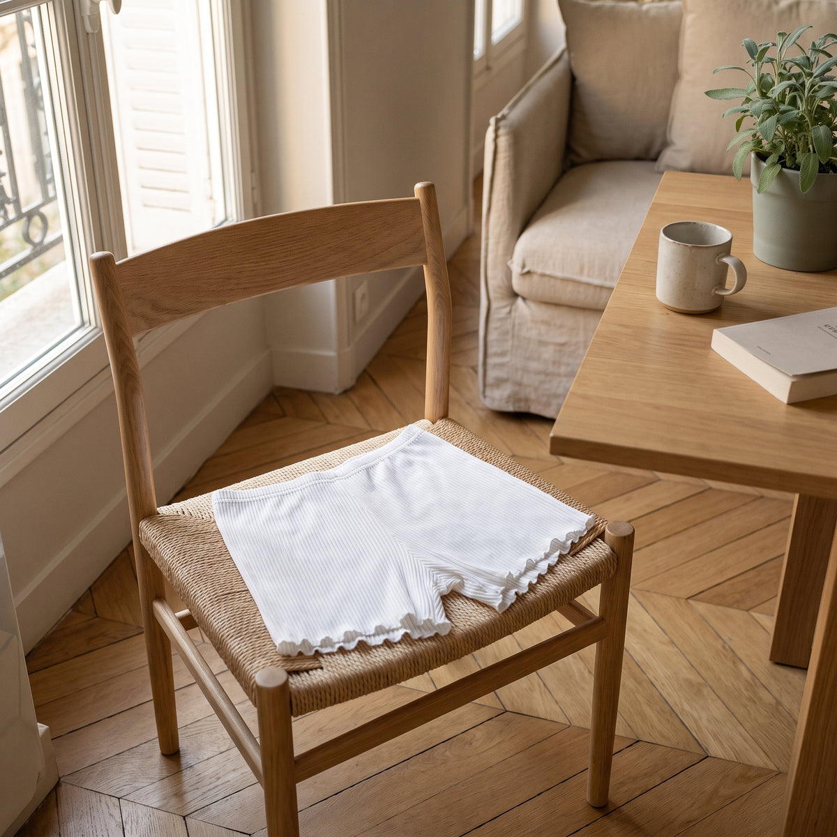 Short boxer blanc pose deplie sur une chaise en bois clair