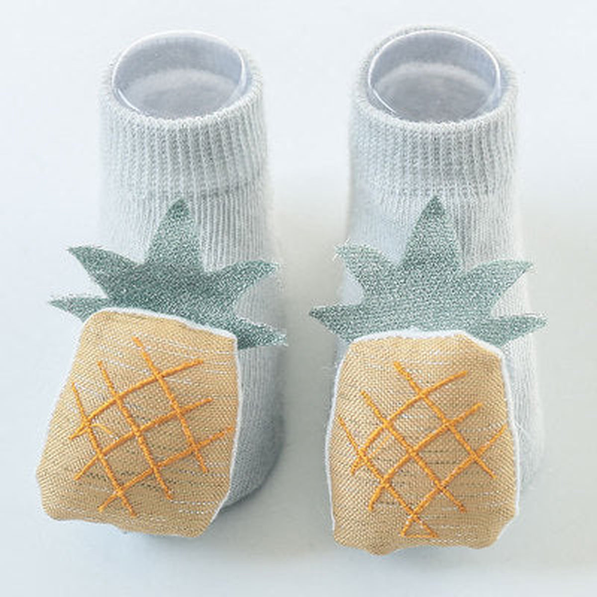 Une paire de chaussettes antidérapantes bébé, motif ananas