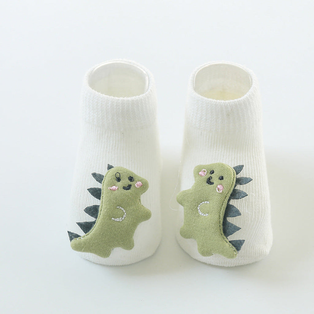 Une paire de chaussettes antidérapantes bébé, motif dinosaure