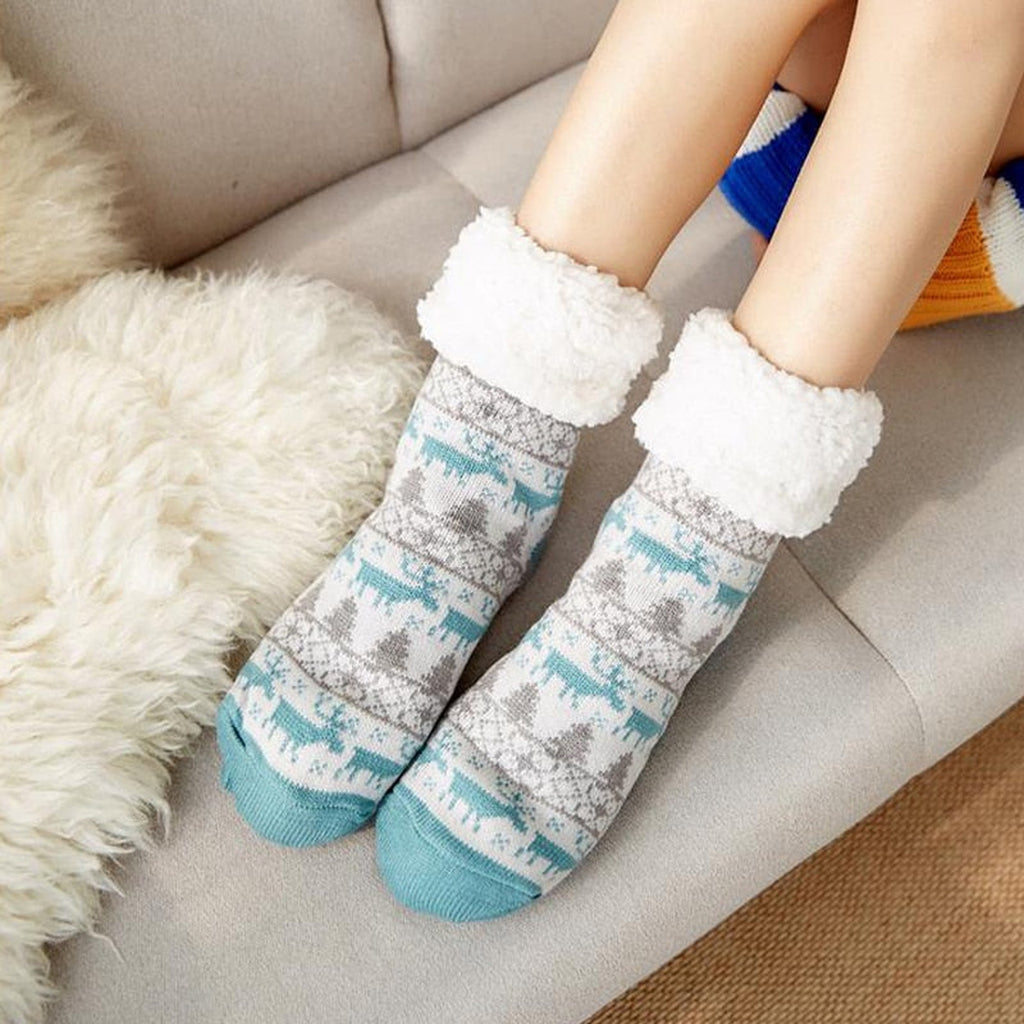 Chaussettes de Noël gris et turquoise portées sur le canapé