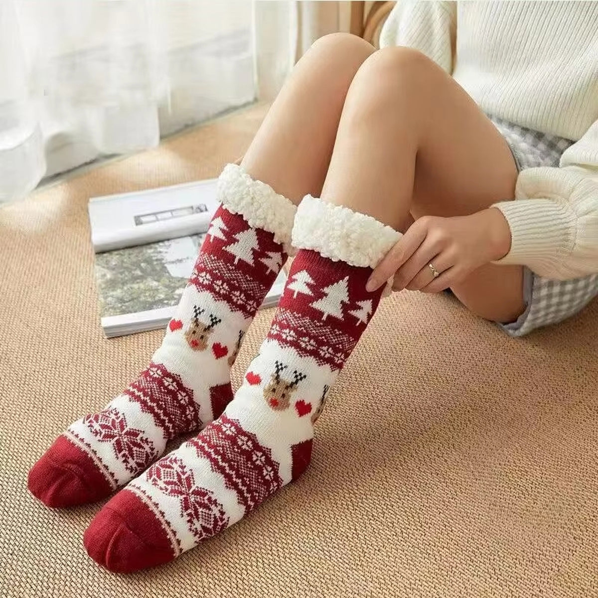 Chaussettes de Noël rouges à revers blanc portées près du canapé