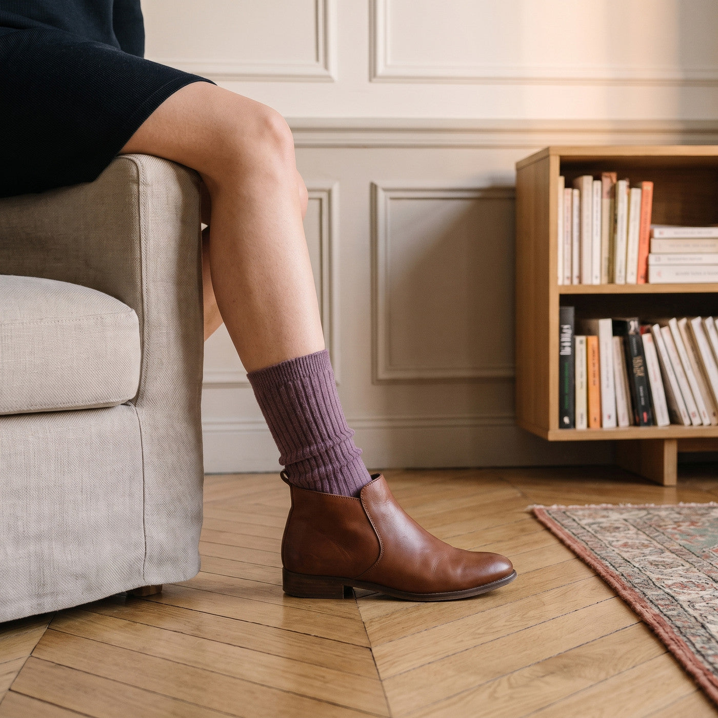 Chaussette côtelée prune dépassant d'une bottine en cuir brun, sur un parquet en point de Hongrie Image