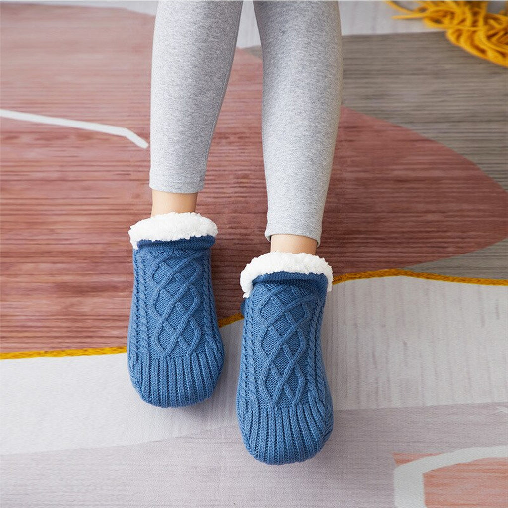 Chaussettes fourrées bleues à revers blanc portées sur un tapis
